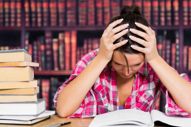 Stressed student studying in college library