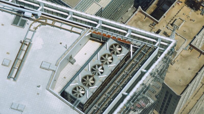 Rooftop of a commercial building with industrial cooling units, illustrating energy inefficiency