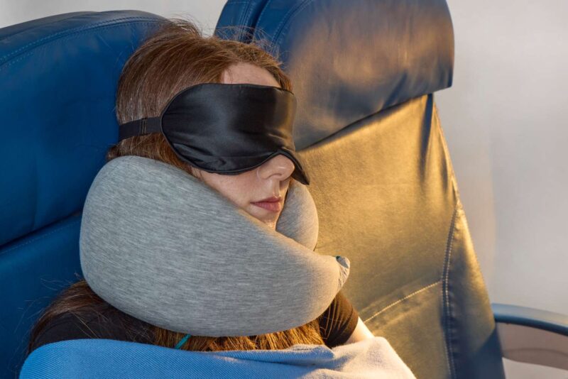 woman with an eye mask sleeping in a plane