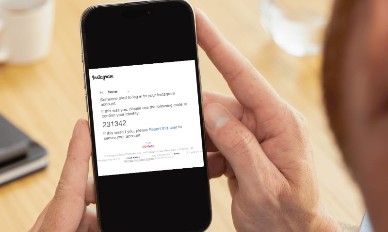 Man looking at phone, reading suspicious phishing message on his e-mail