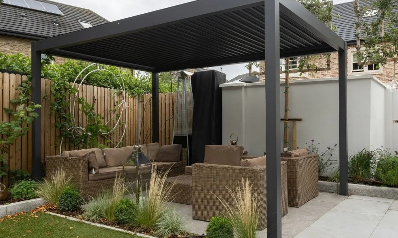 Modern patio with a metal pergola, wicker sofas, brown cushions, and a glass table