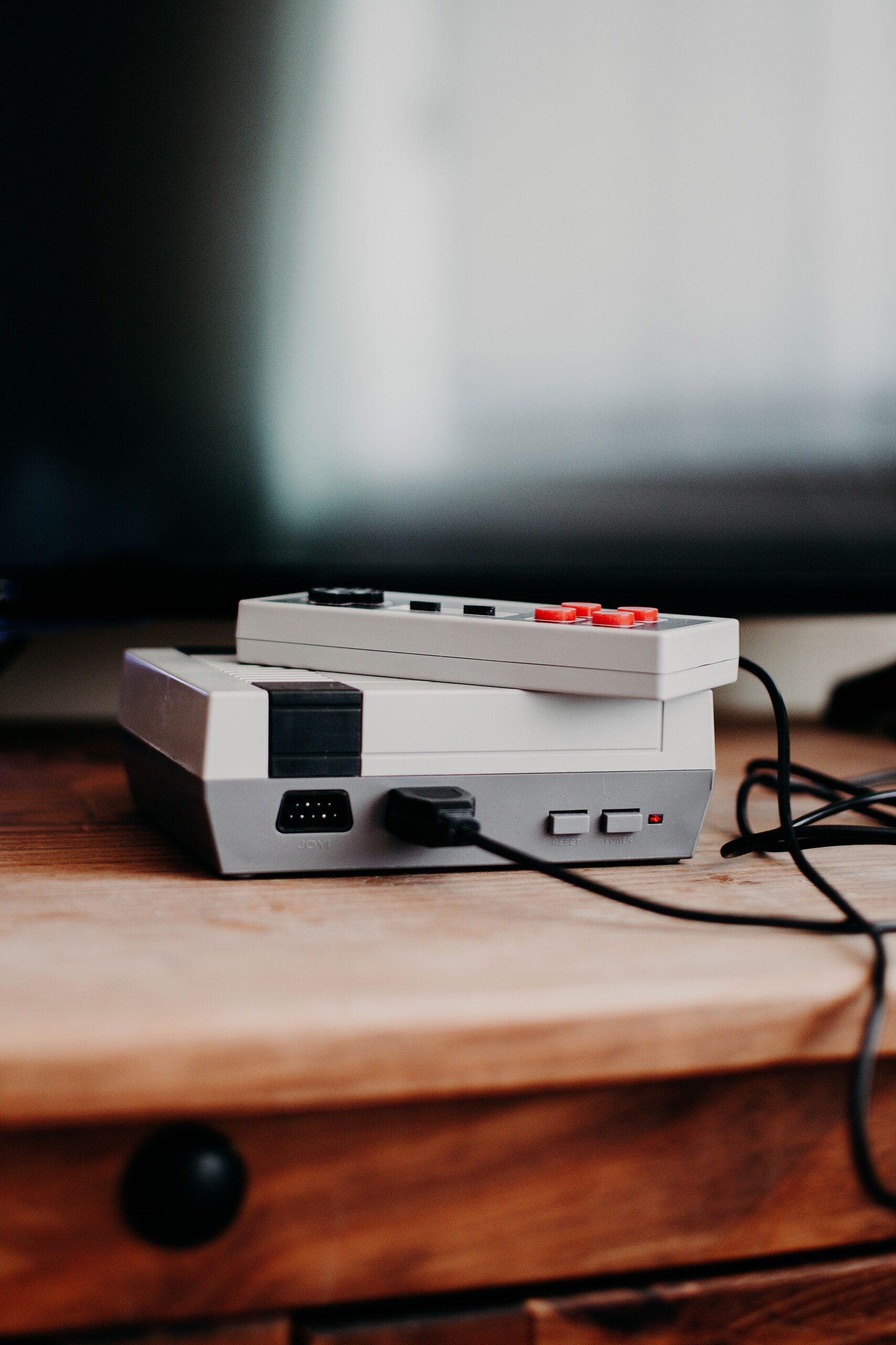 Vintage gaming console and controller resting on a wooden desk, evoking classic video game nostalgia