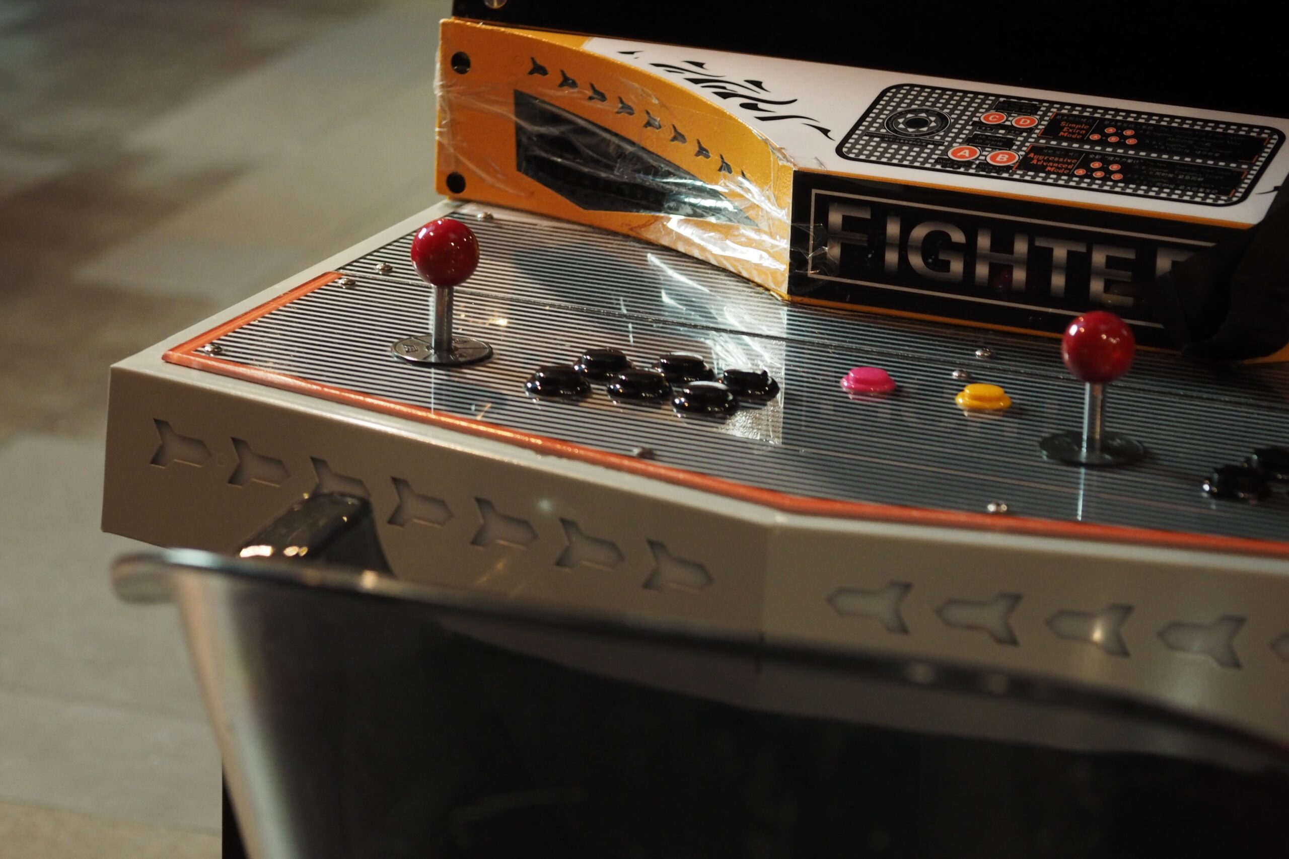 Close-up of a vintage arcade game control panel with joysticks and buttons