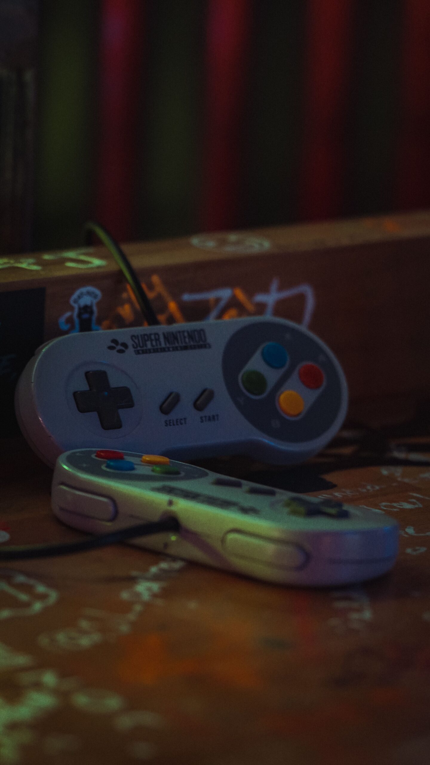 Close-up of vintage Super Nintendo game controllers on a dark surface