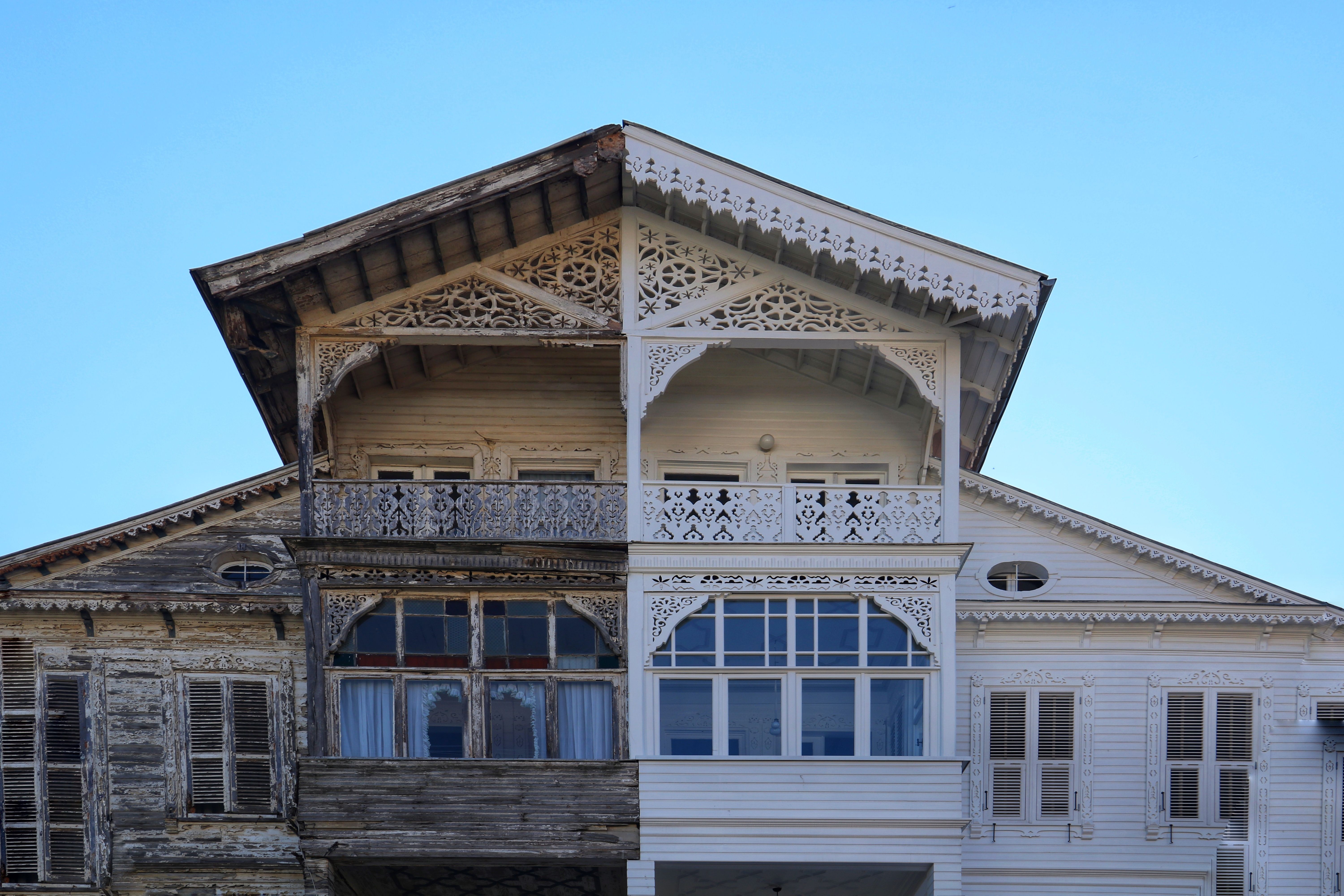 Half-renovated wooden house facade showing old versus new siding