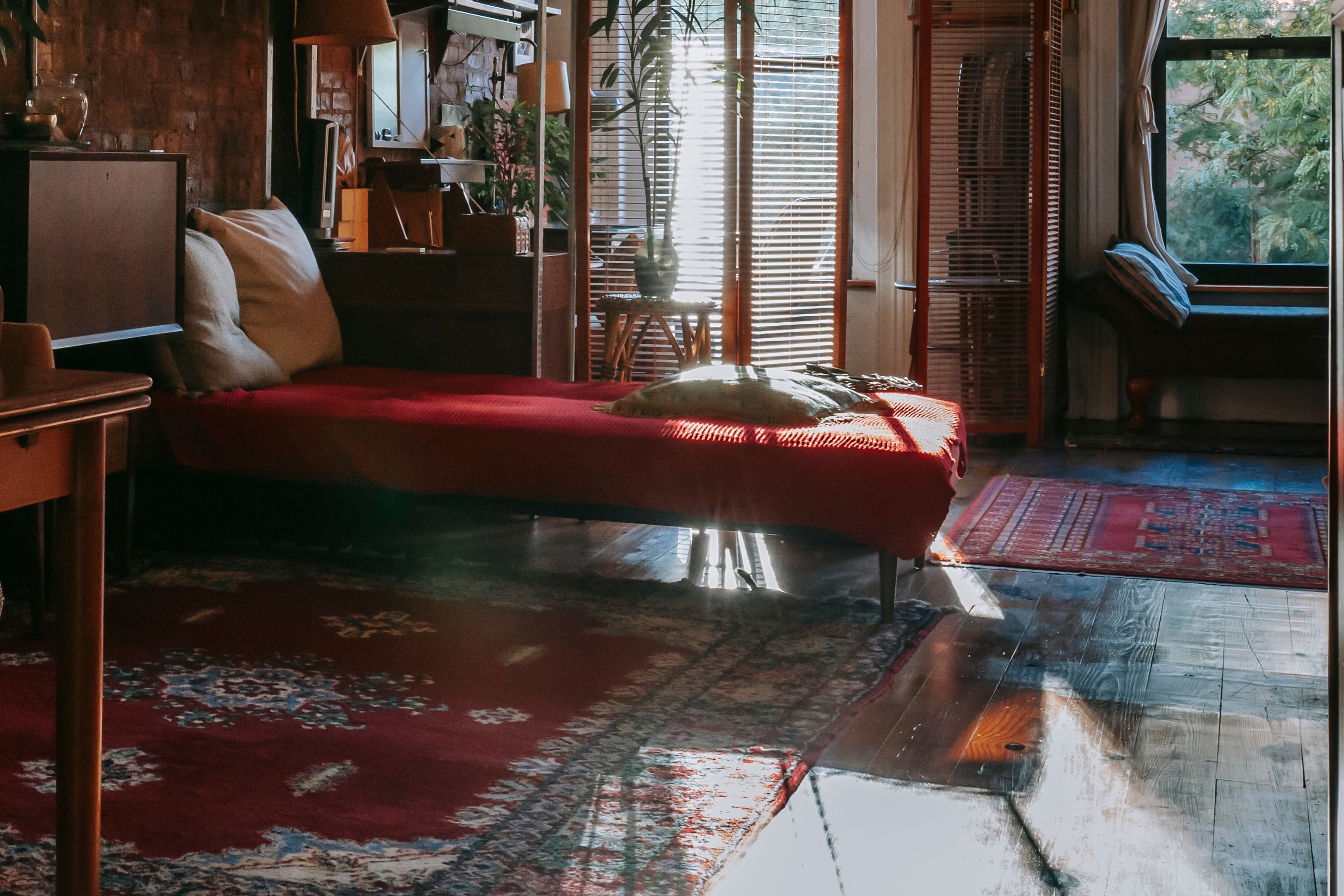 Bedroom with vintage wooden furniture and a soft area rug layered over hardwood flooring
