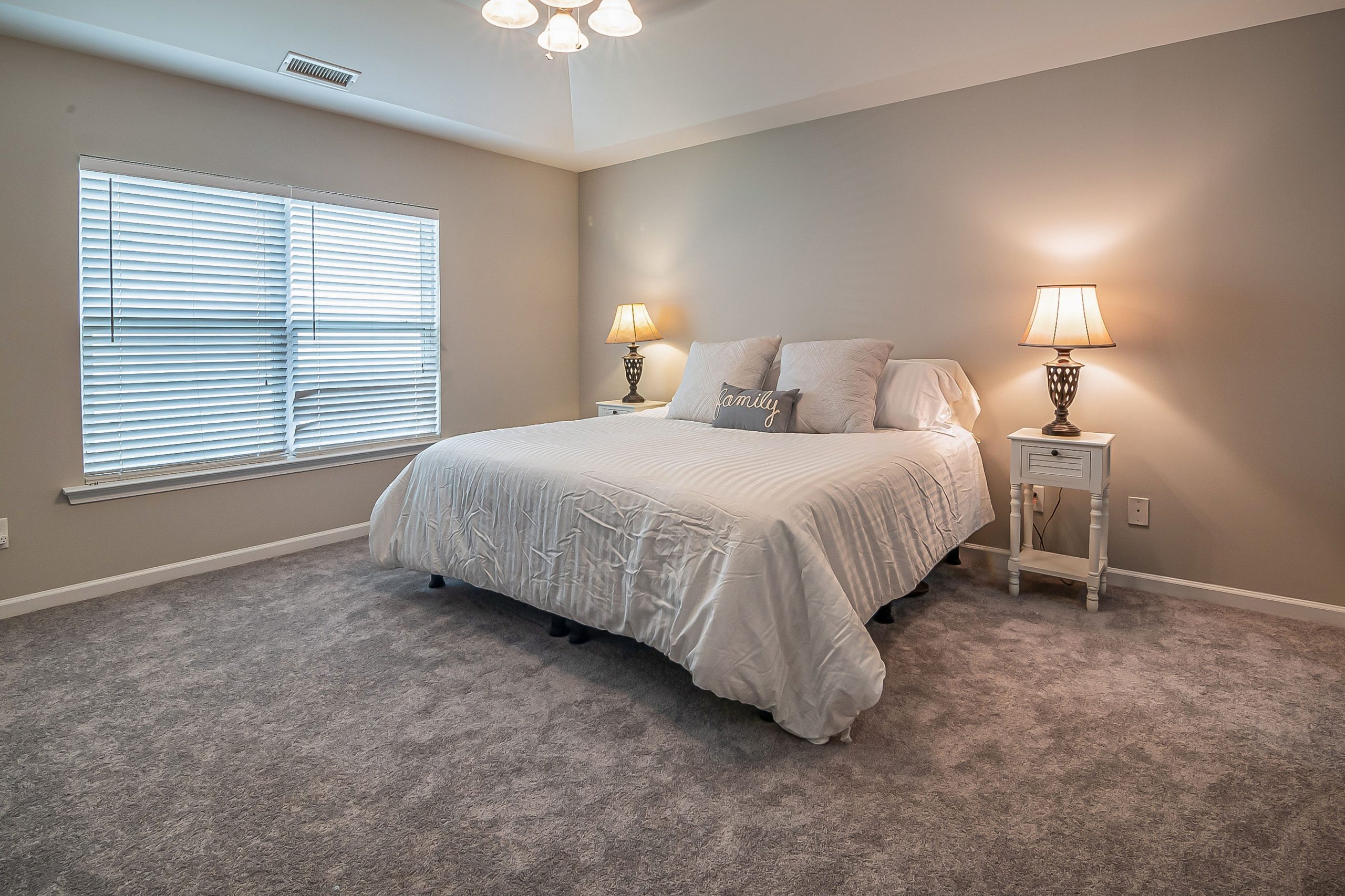 Cozy carpeted bedroom with king-size bed and soft ambient lighting
