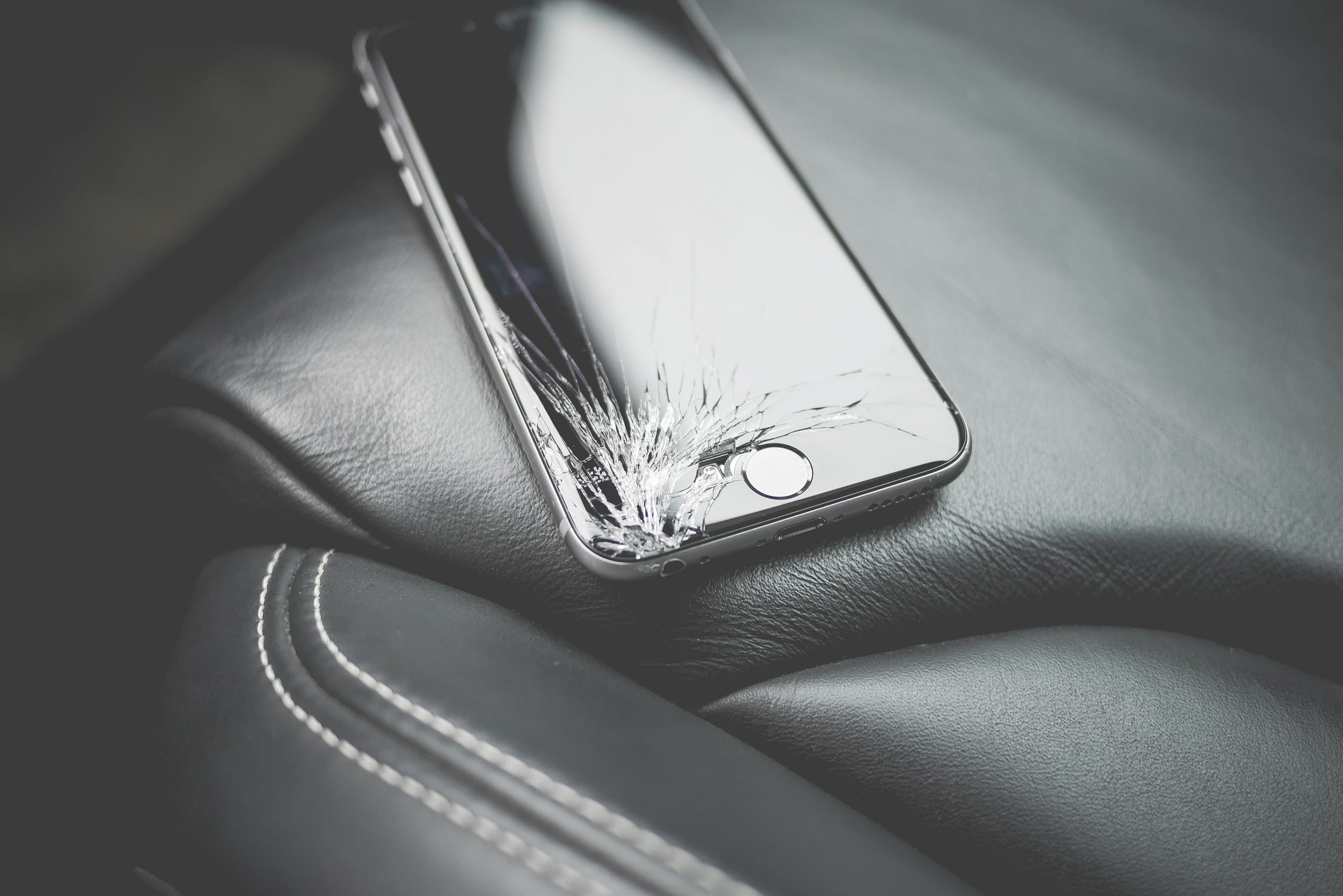 Close-up of a smartphone with a cracked screen, illustrating sudden device damage and data loss