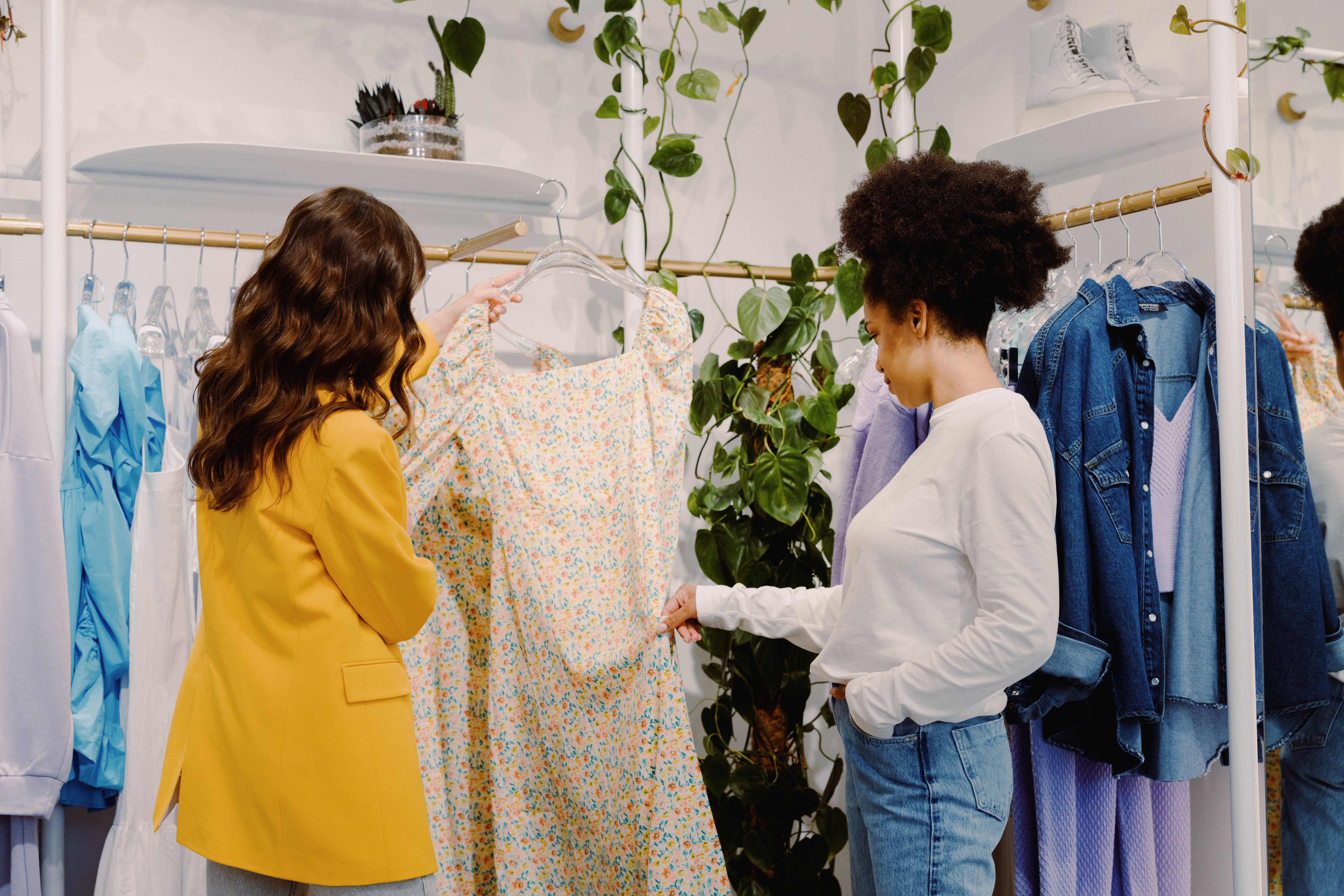 Two women browsing clothing displayed in a trendy small business boutique