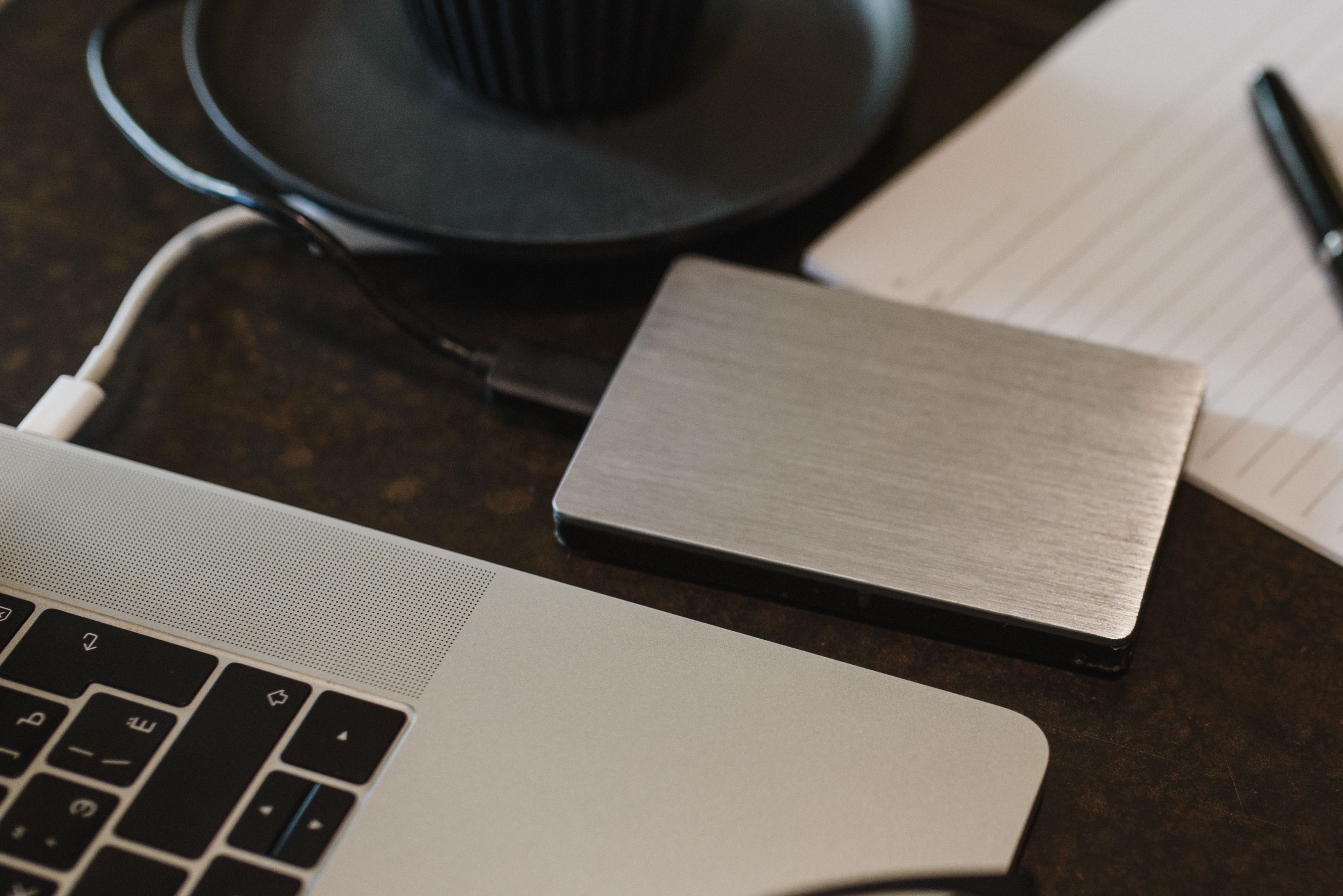 External hard drive connected to a laptop with a USB cable for backing up photos, videos, and files
