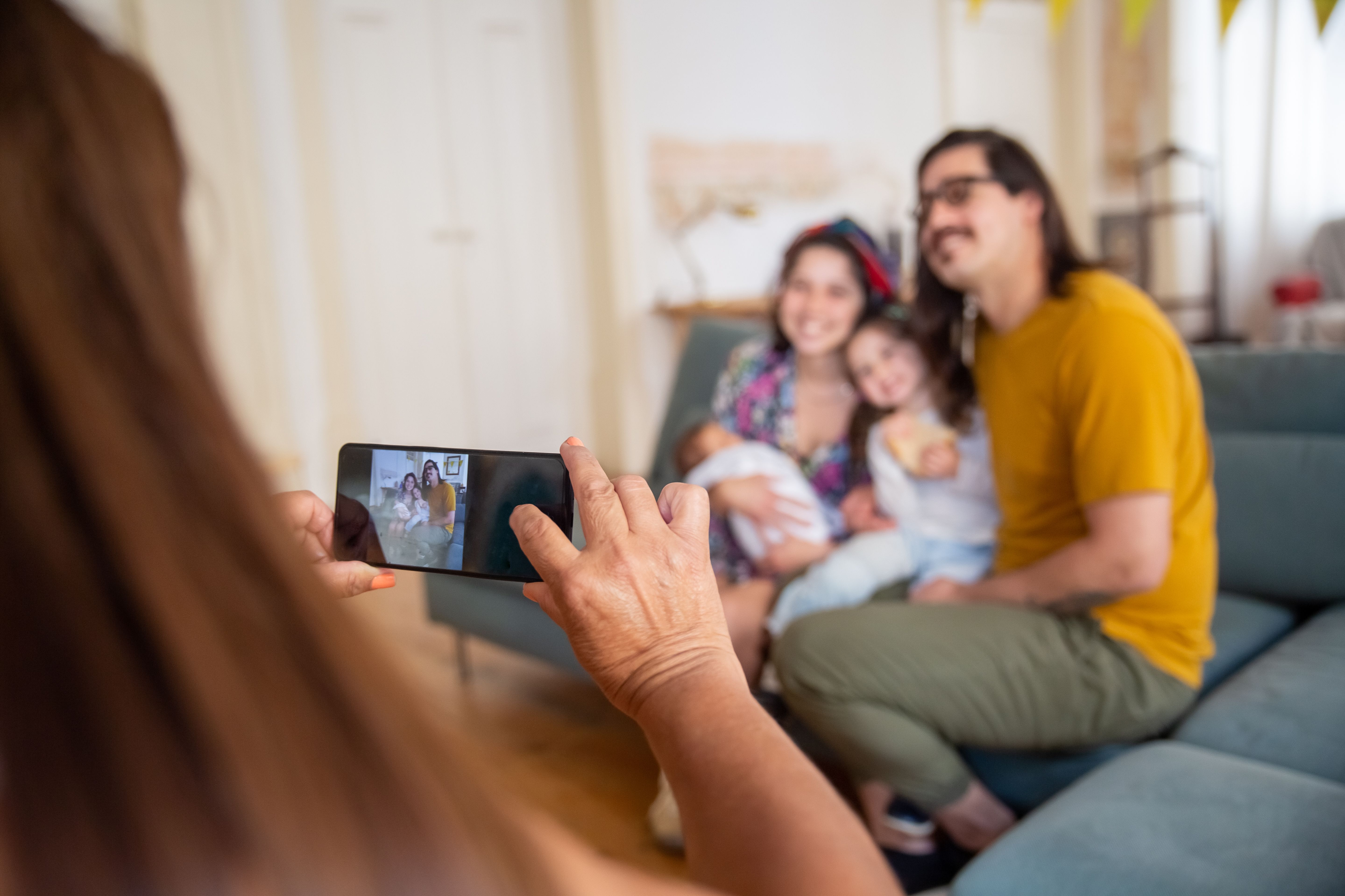 Happy family posing for a smartphone photo, capturing irreplaceable memories worth backing up