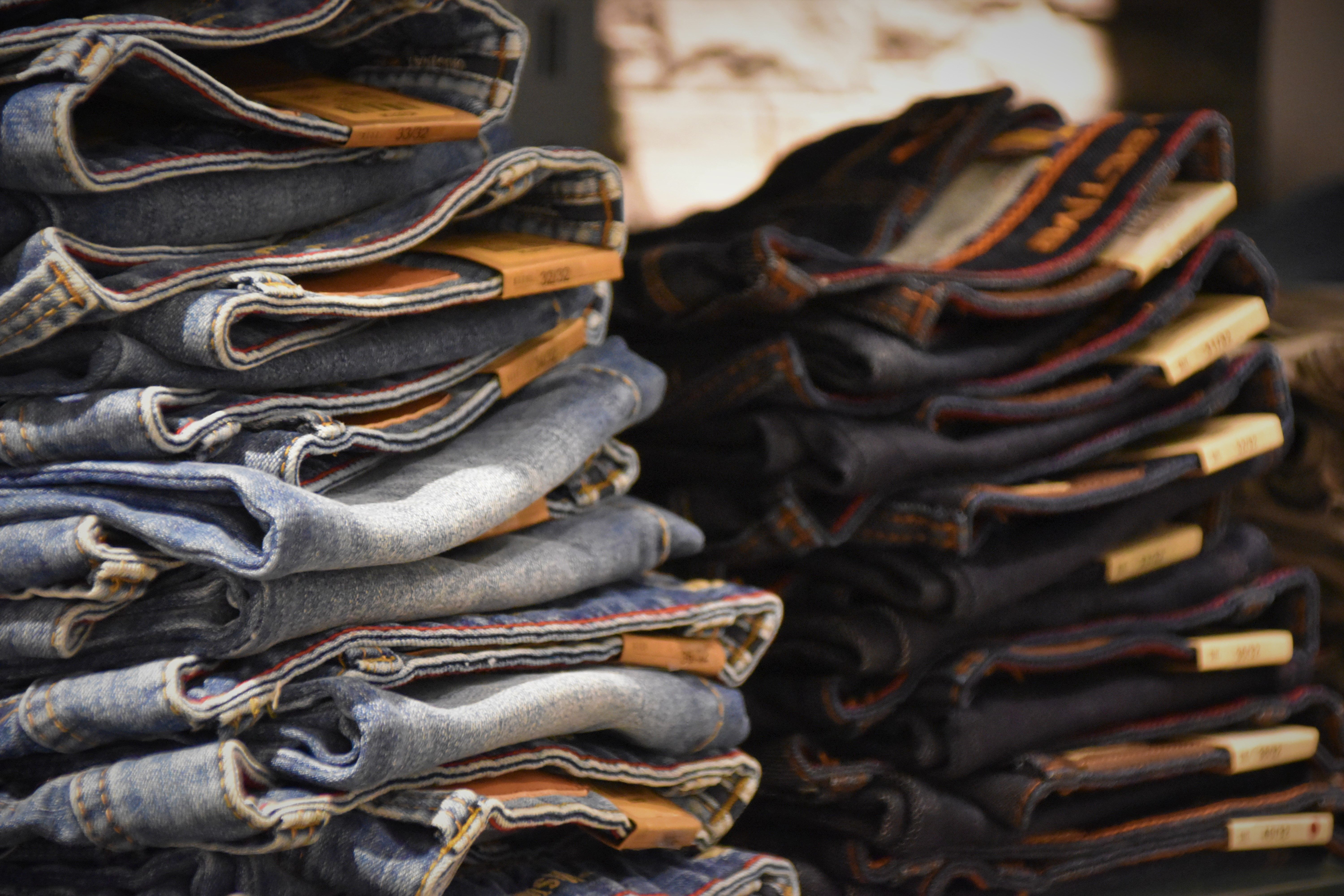 Close-up of folded denim jeans stacked in a retail store setting