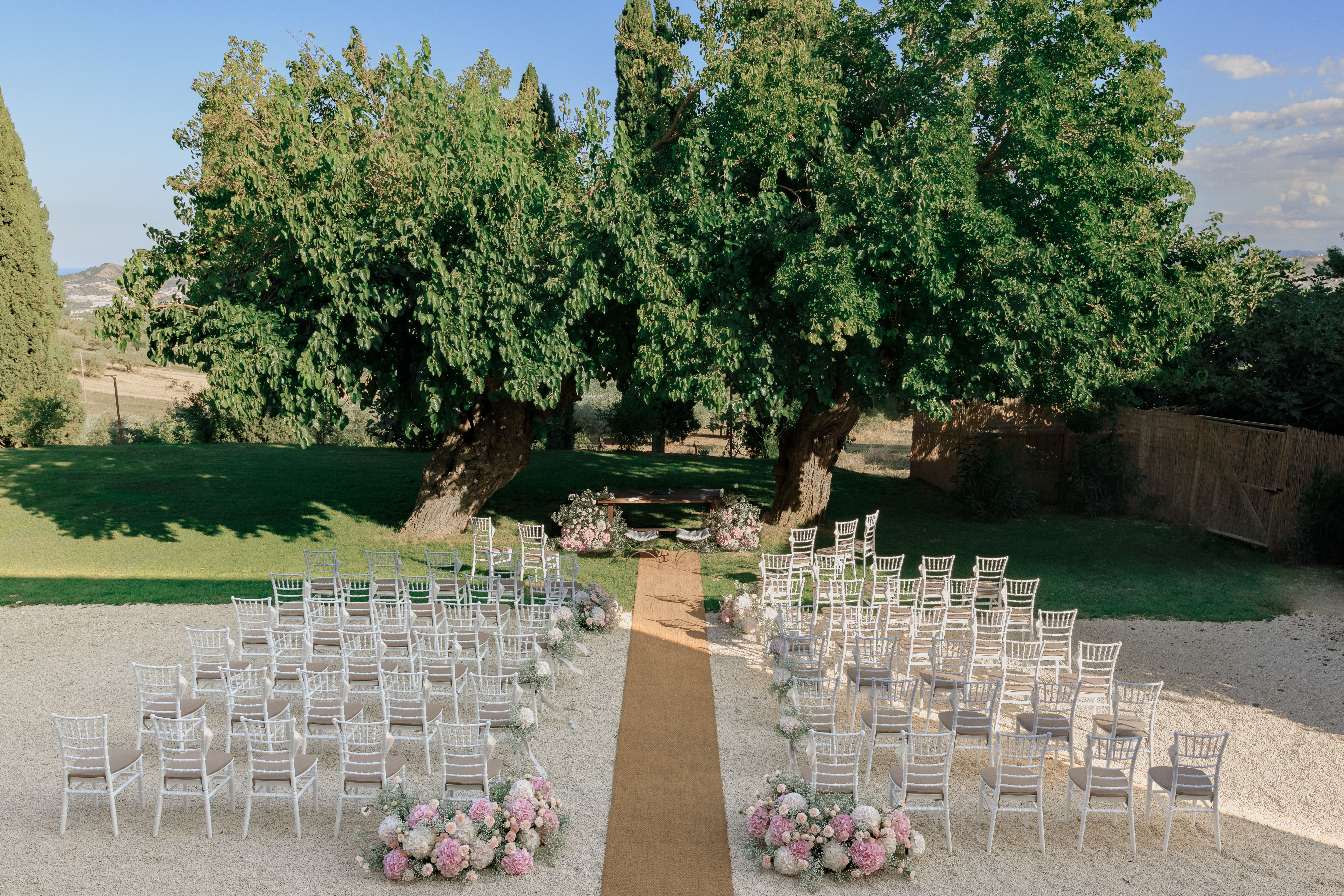 Outdoor wedding ceremony setup with lush floral arrangements in an Italian garden