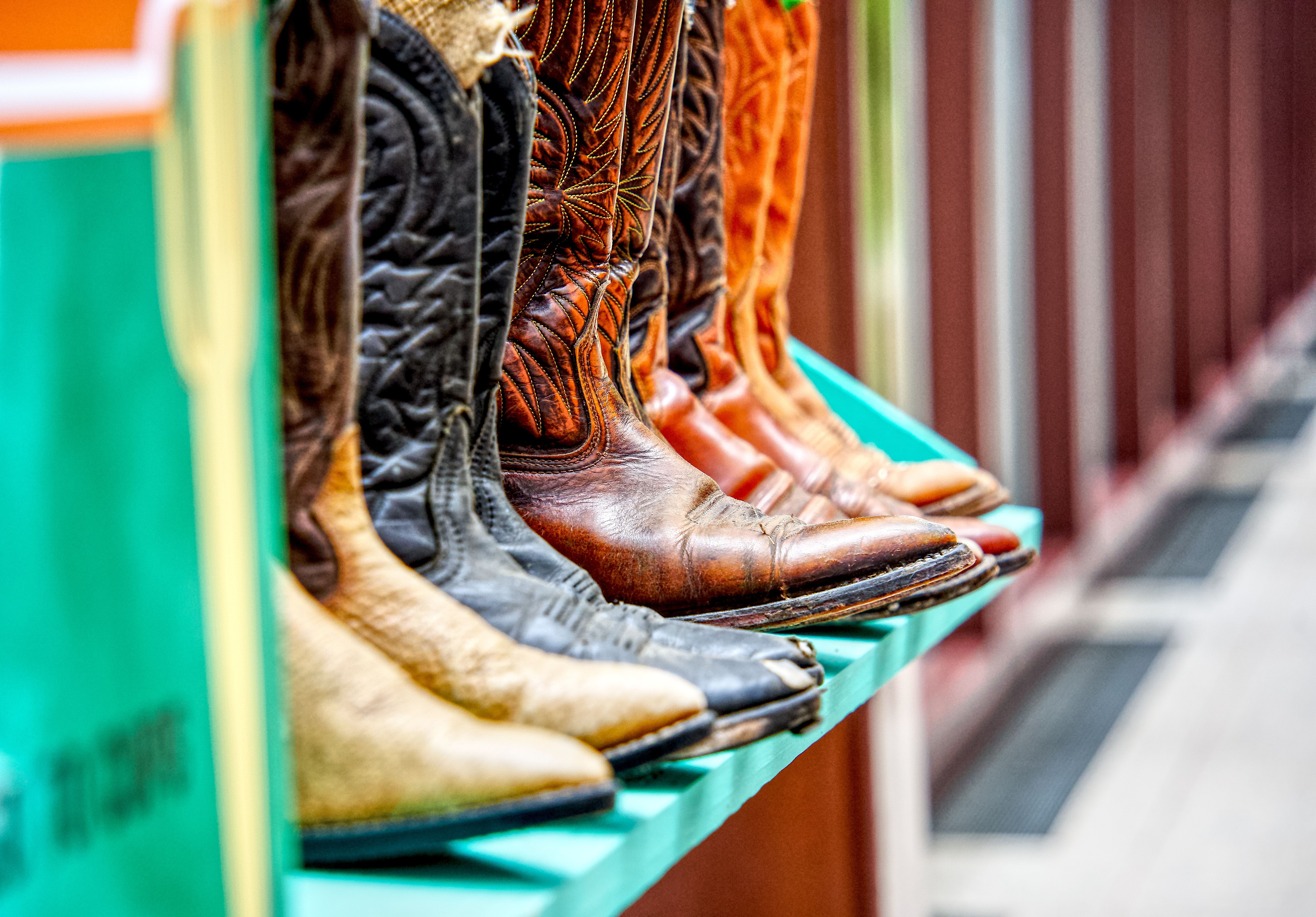 Colorful display of leather cowboy boots on a shelf showcasing detailed craftsmanship