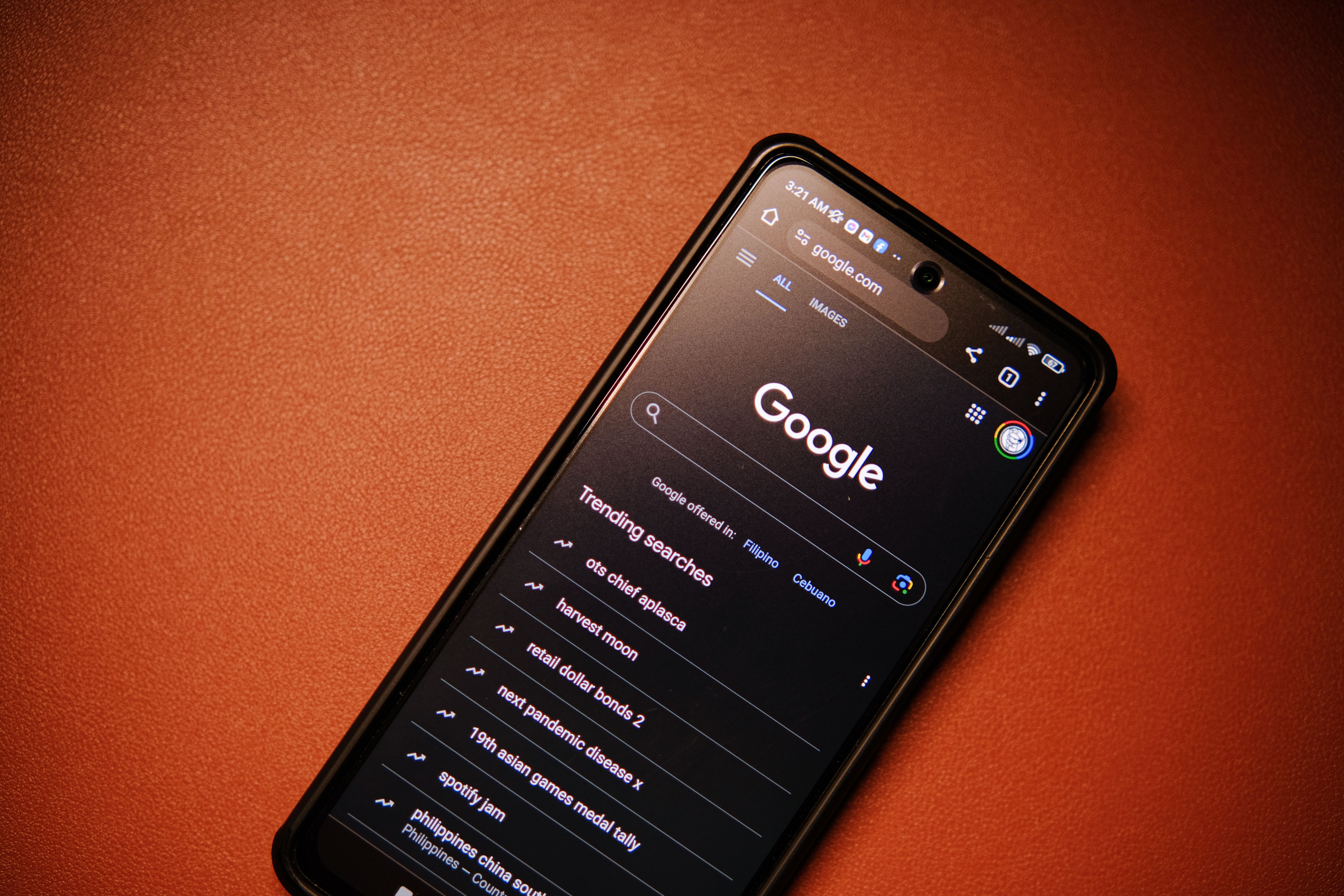 Smartphone displaying Google Search trends on a table at night