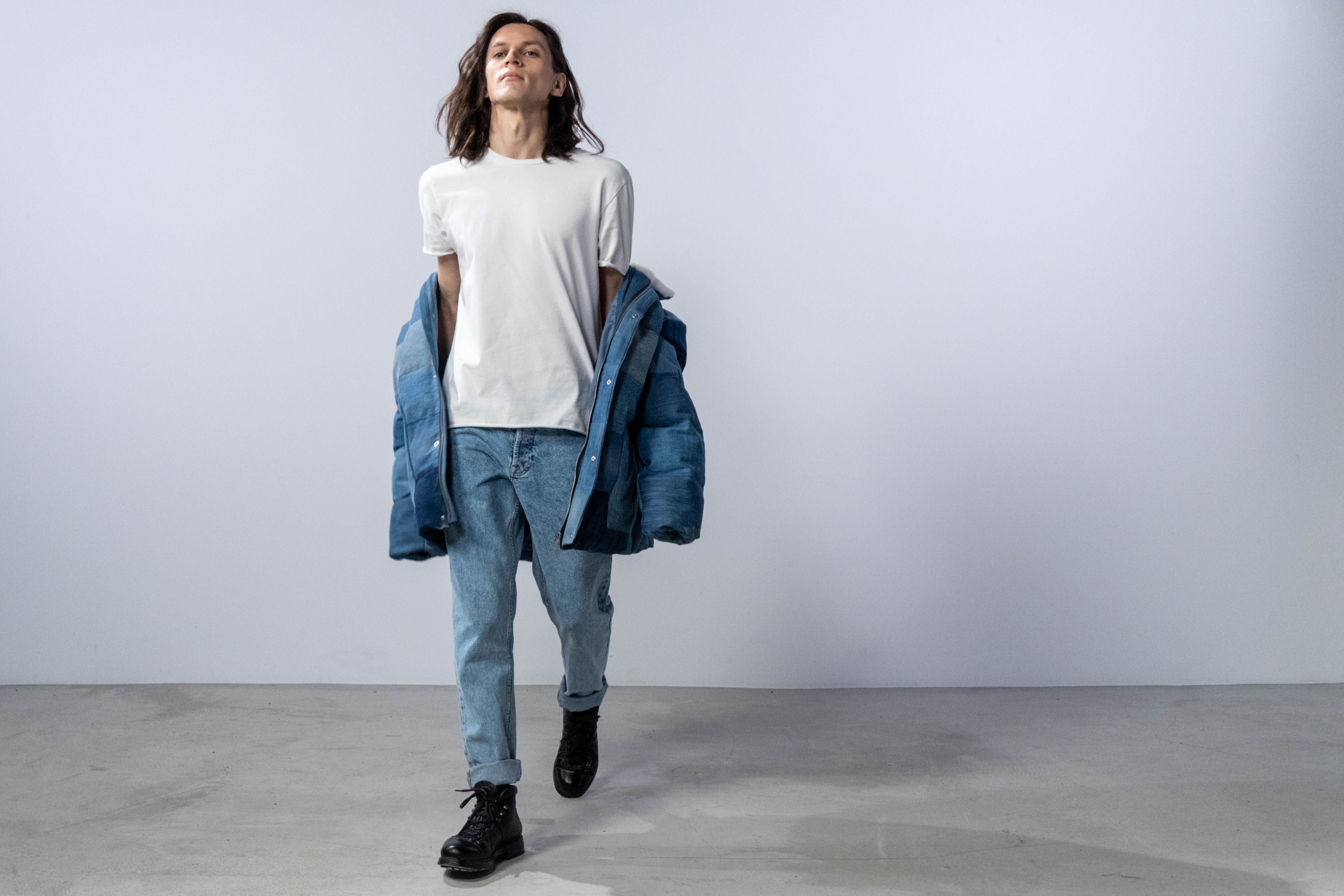 Fashionable male model wearing a denim jacket and jeans in a studio shoot
