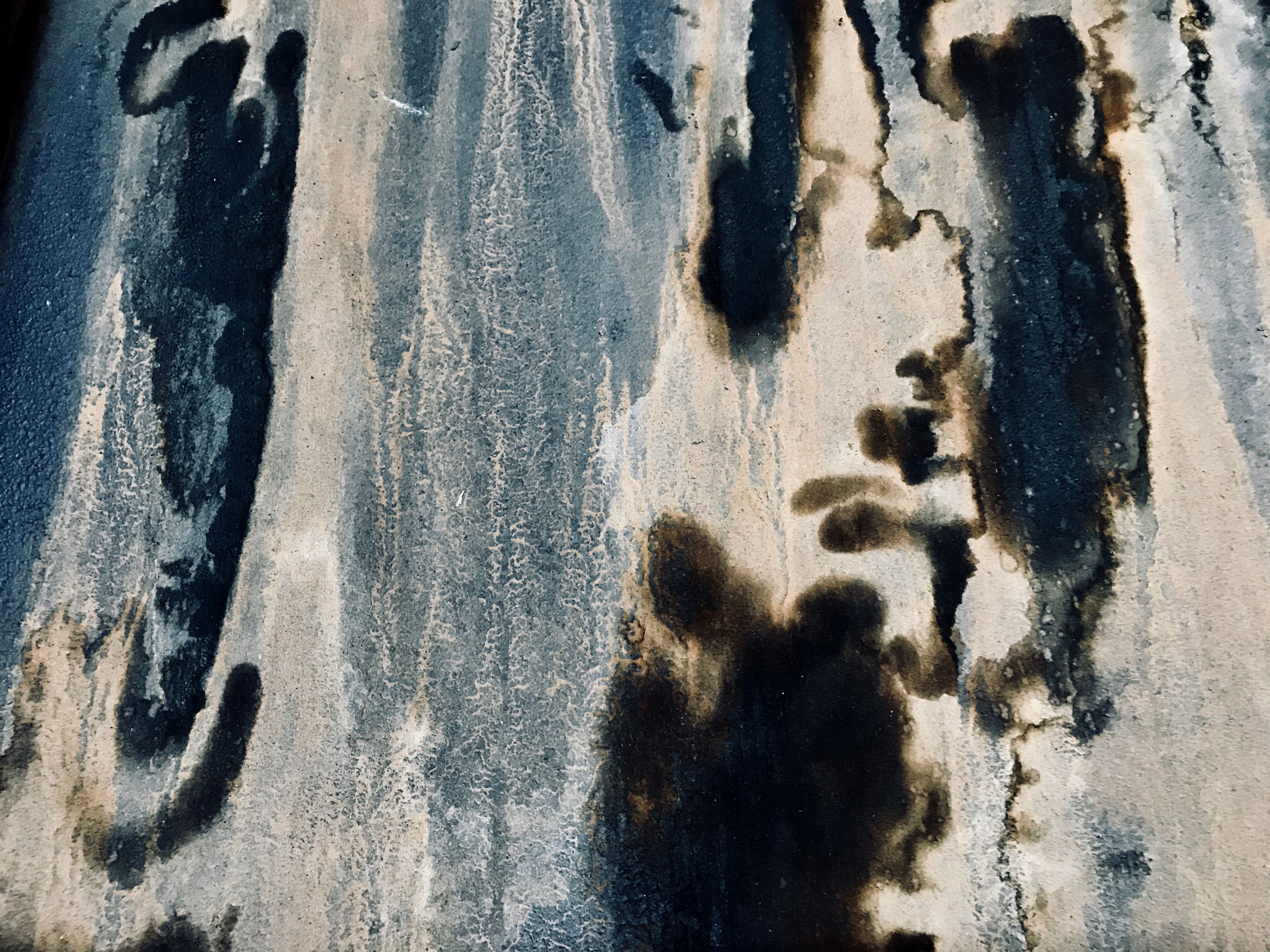 Weathered wall covered in black mildew stains indicating moisture behind the plaster