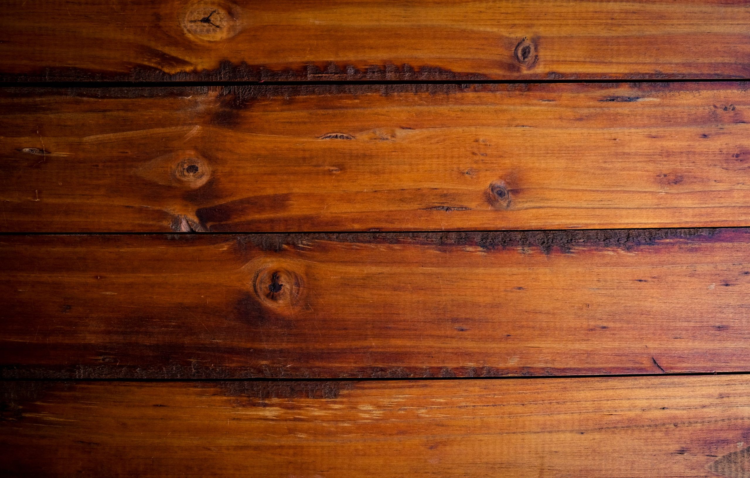 Close-up texture of freshly polished and refreshed wooden floorboards showing rich grain and a glossy finish