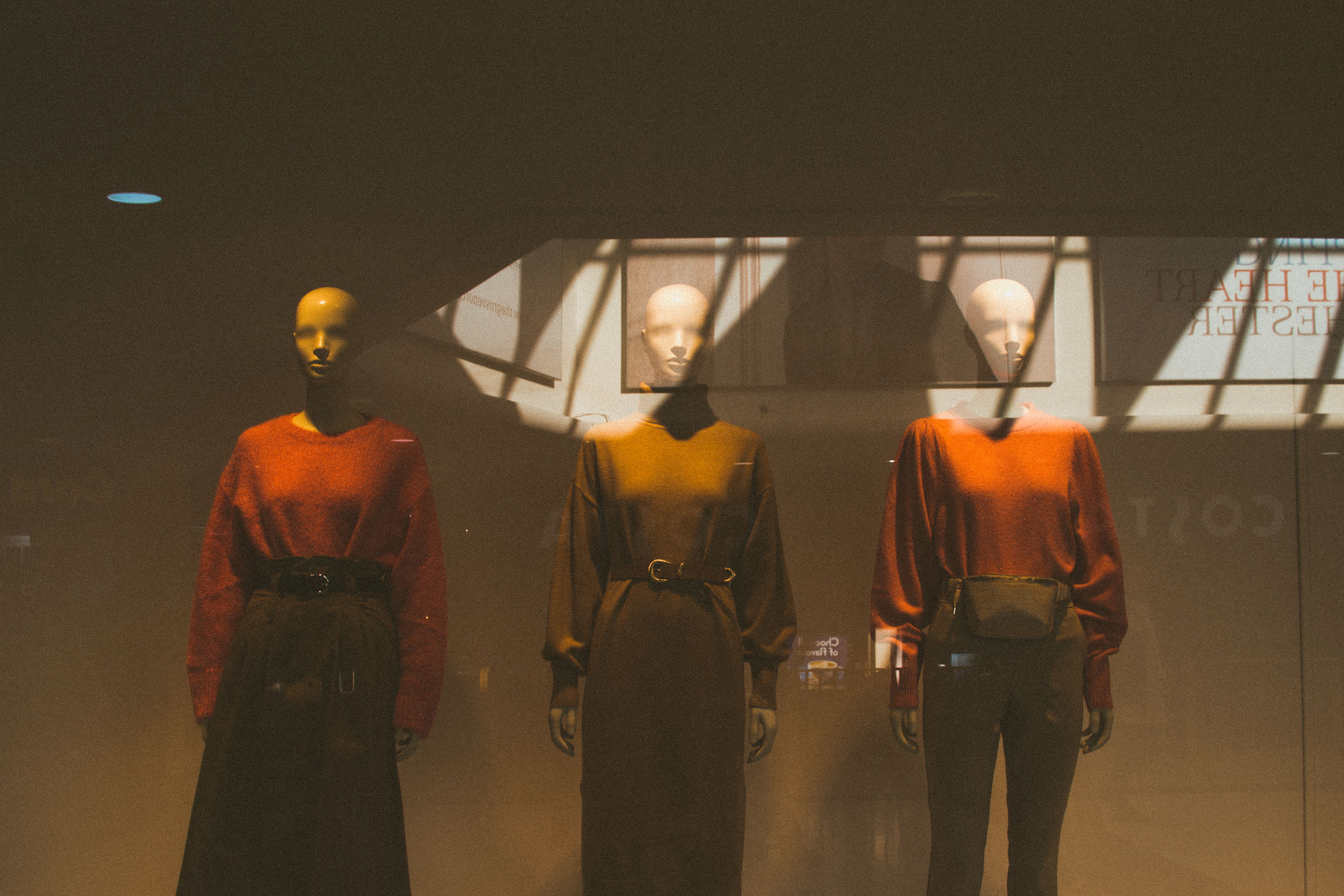 Stylish store window display with mannequins dressed in autumn fashion attracting shoppers inside