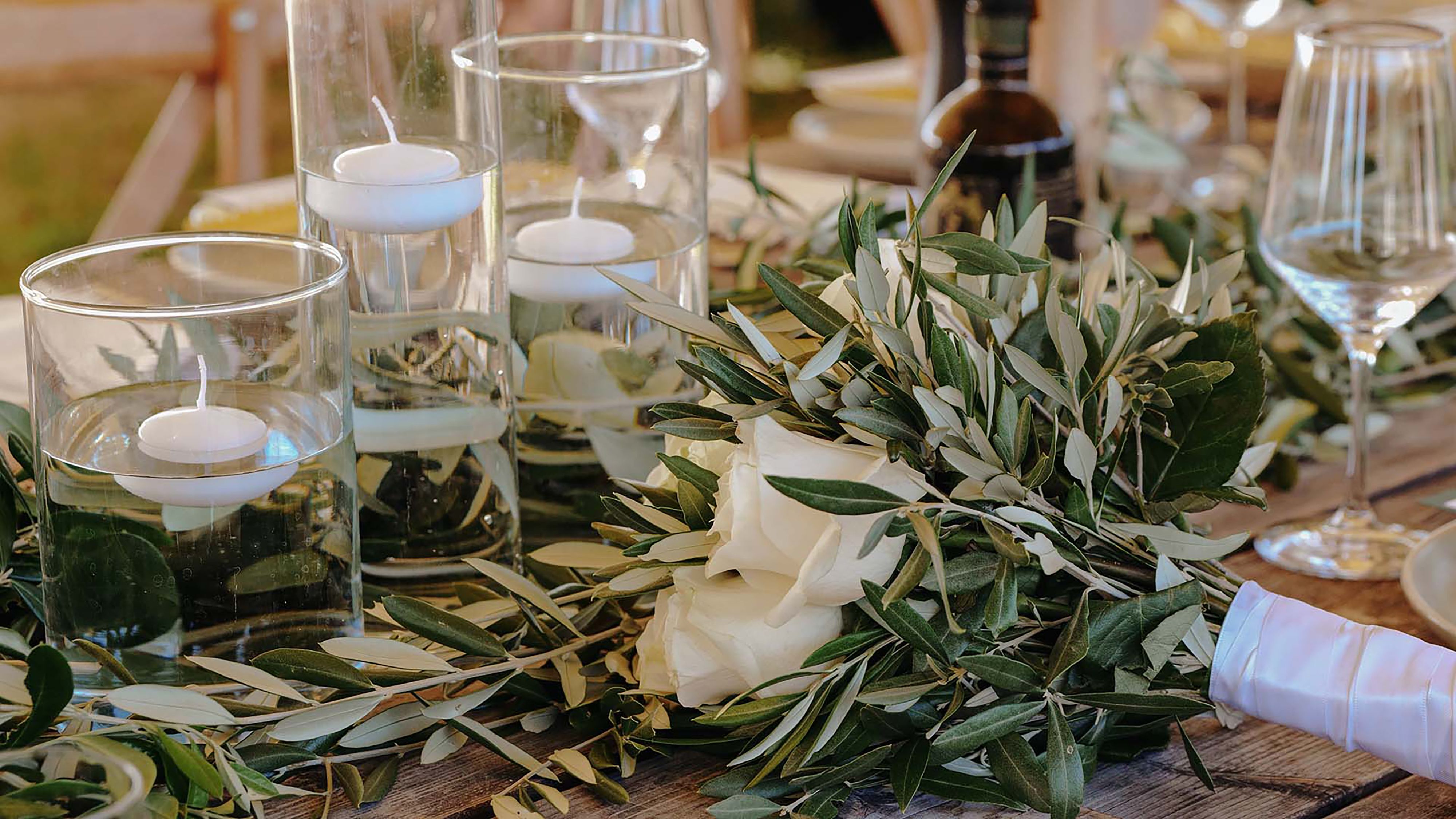 Romantic table setting with candles and flowers designed for a Tuscany wedding reception