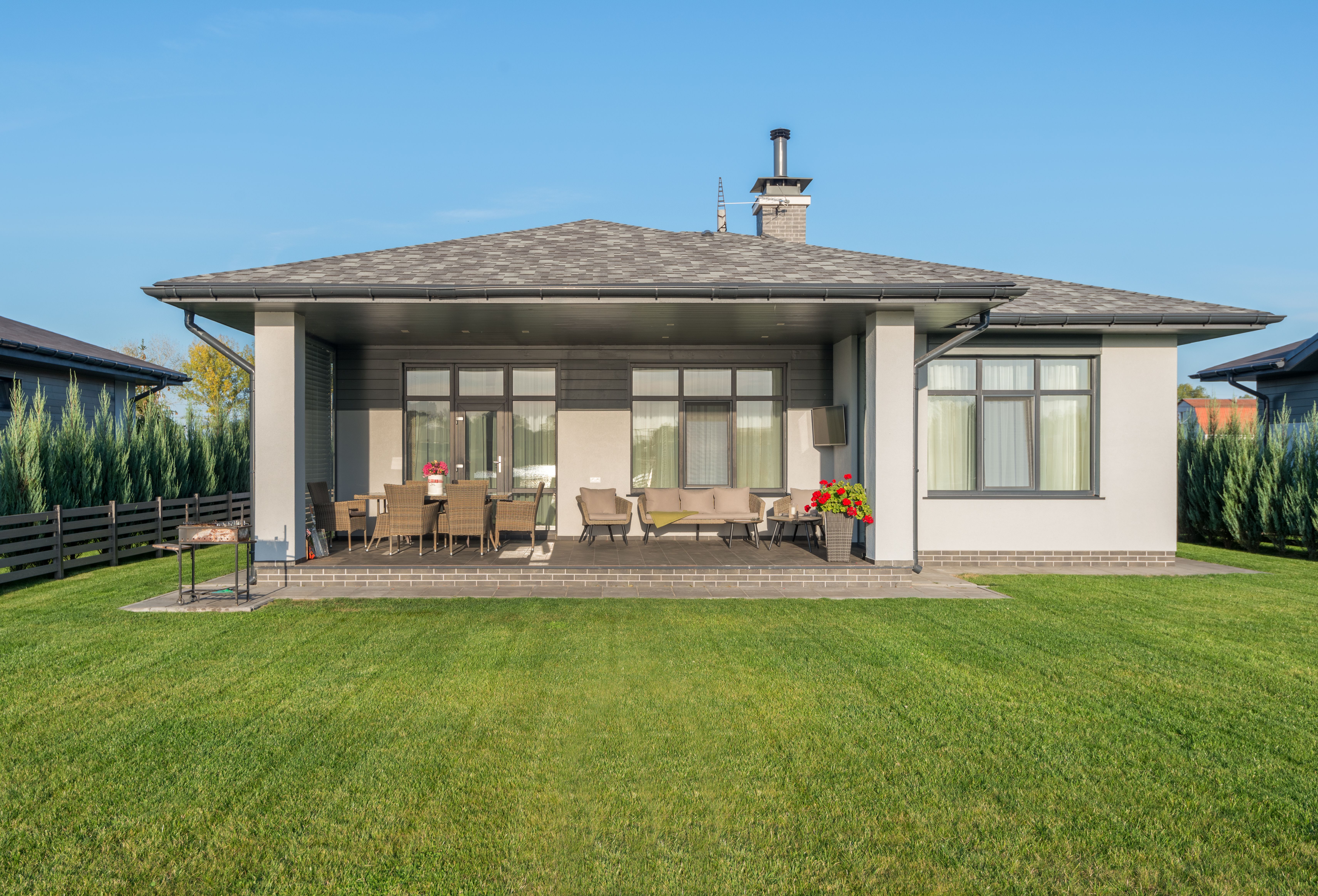 Contemporary house exterior with a large backyard patio and manicured lawn
