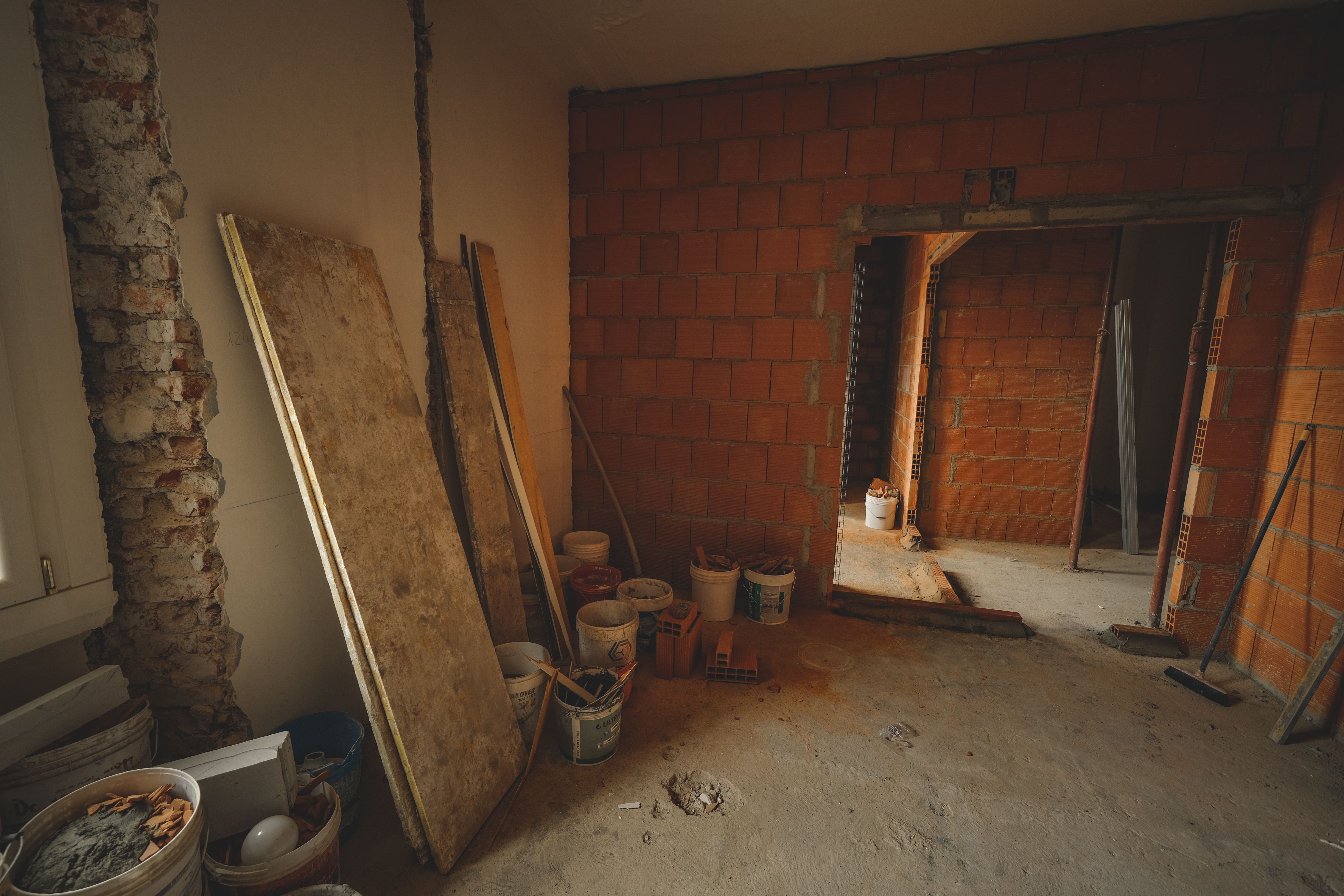 A red brick wall under construction with tools and materials scattered around in a renovation project