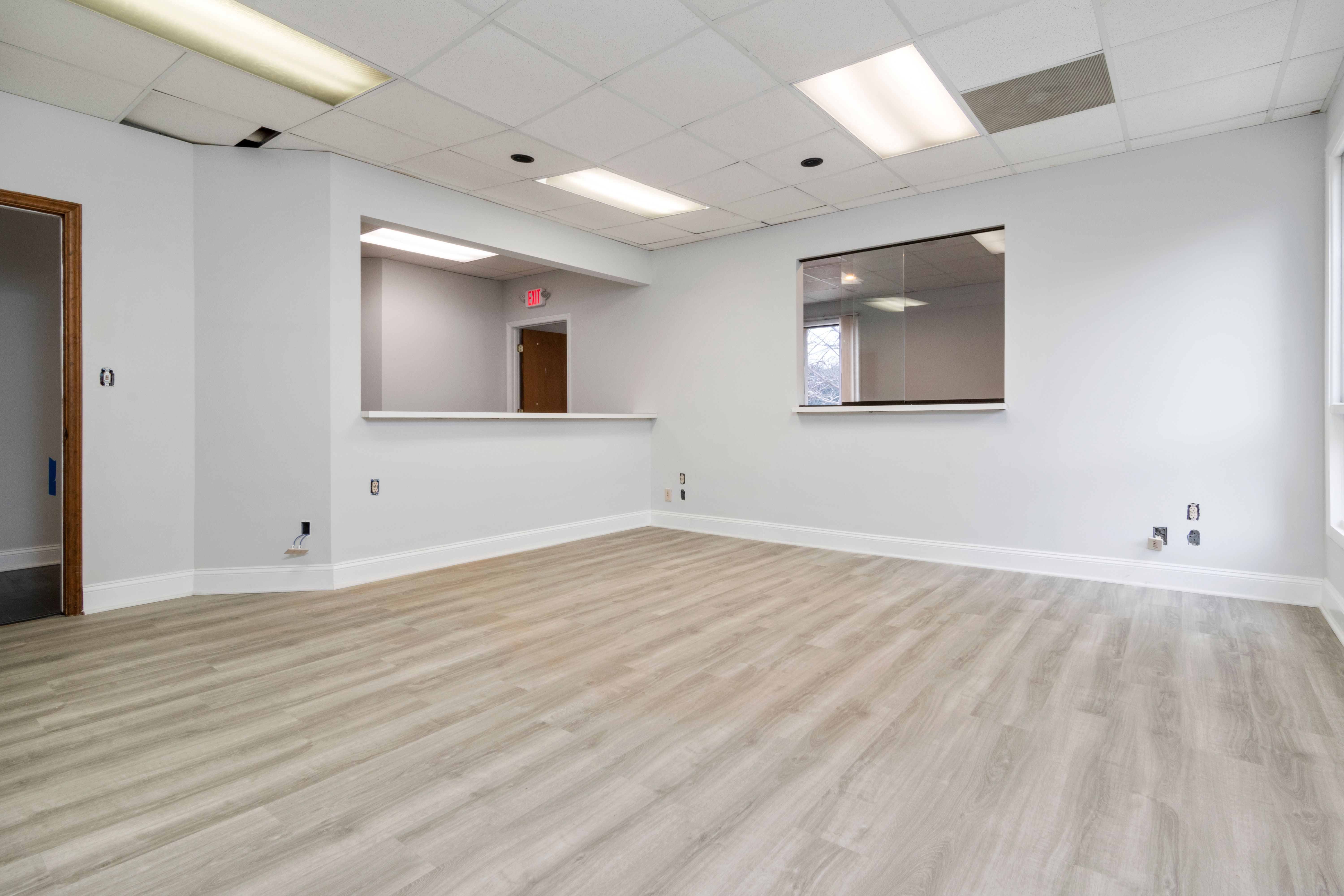 Modern and spacious empty room with wooden flooring and recessed lighting