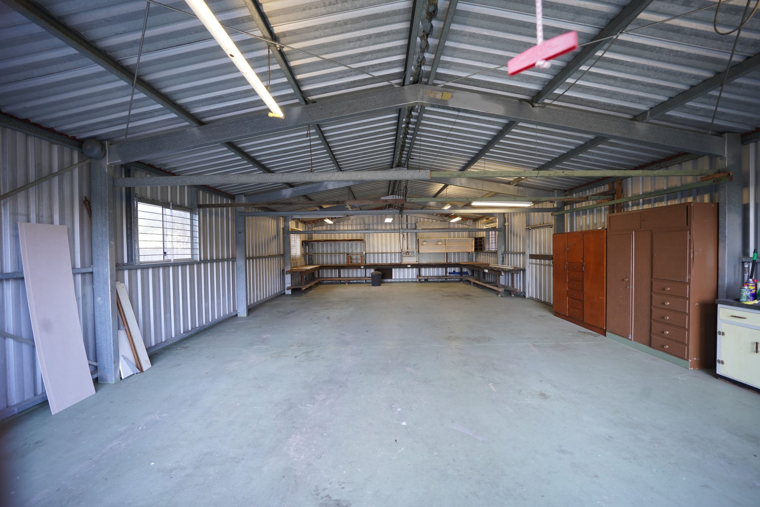 Empty industrial garage with metal walls and a concrete floor, ready for renovation