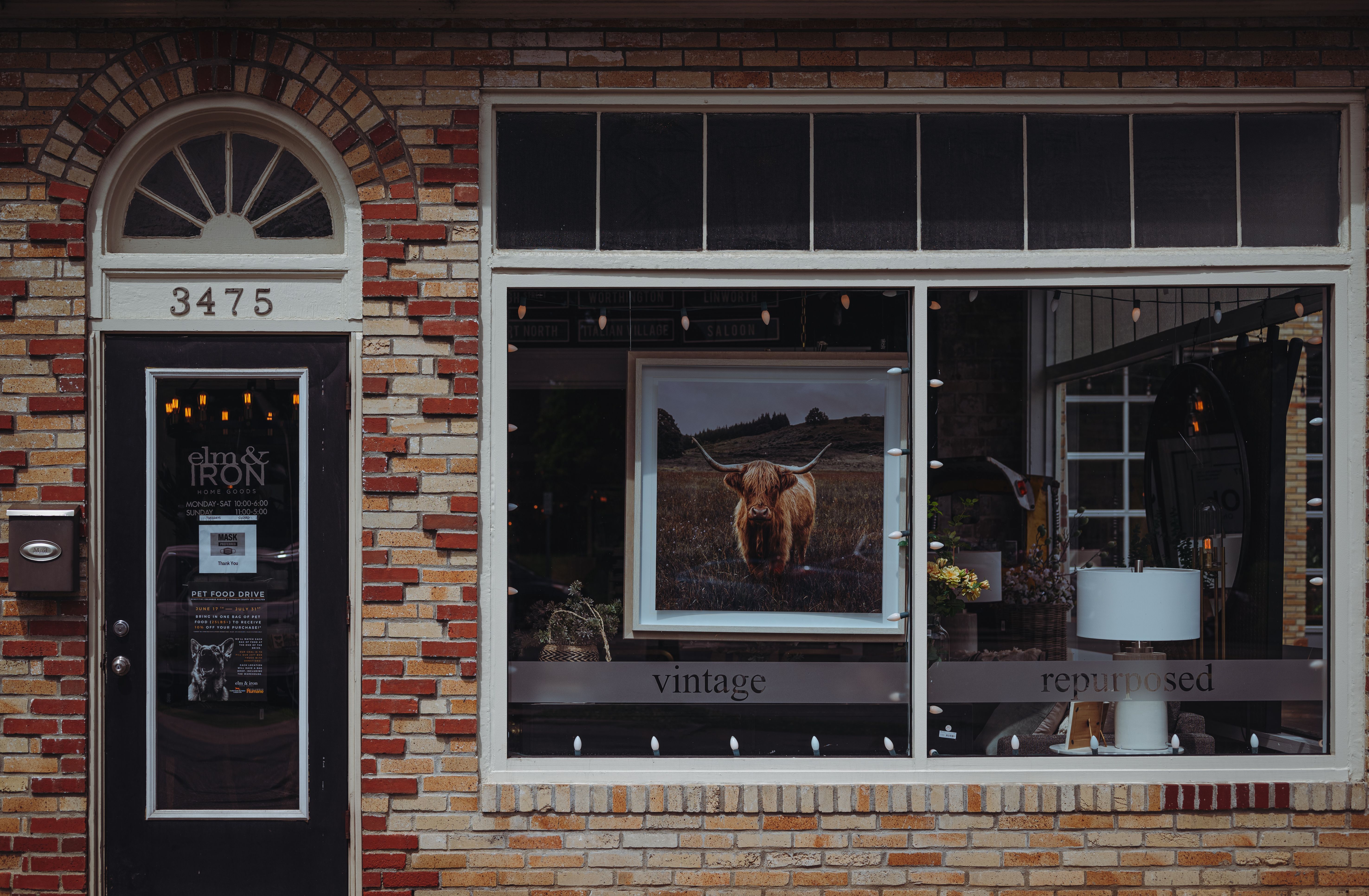 A picturesque vintage café storefront with a brick facade, featuring unique decor and signage