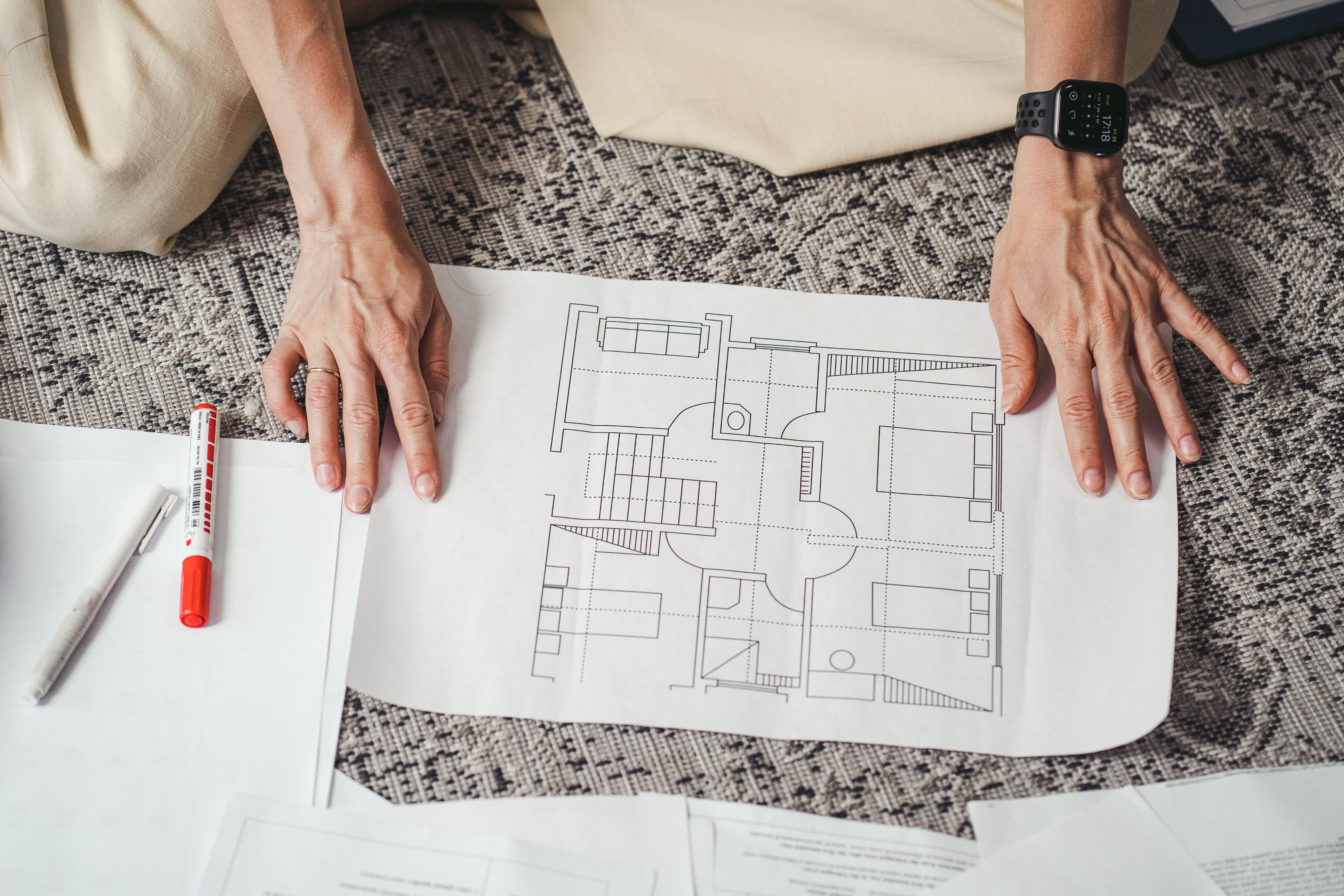 Hands on a detailed architectural floor plan showing home design layout