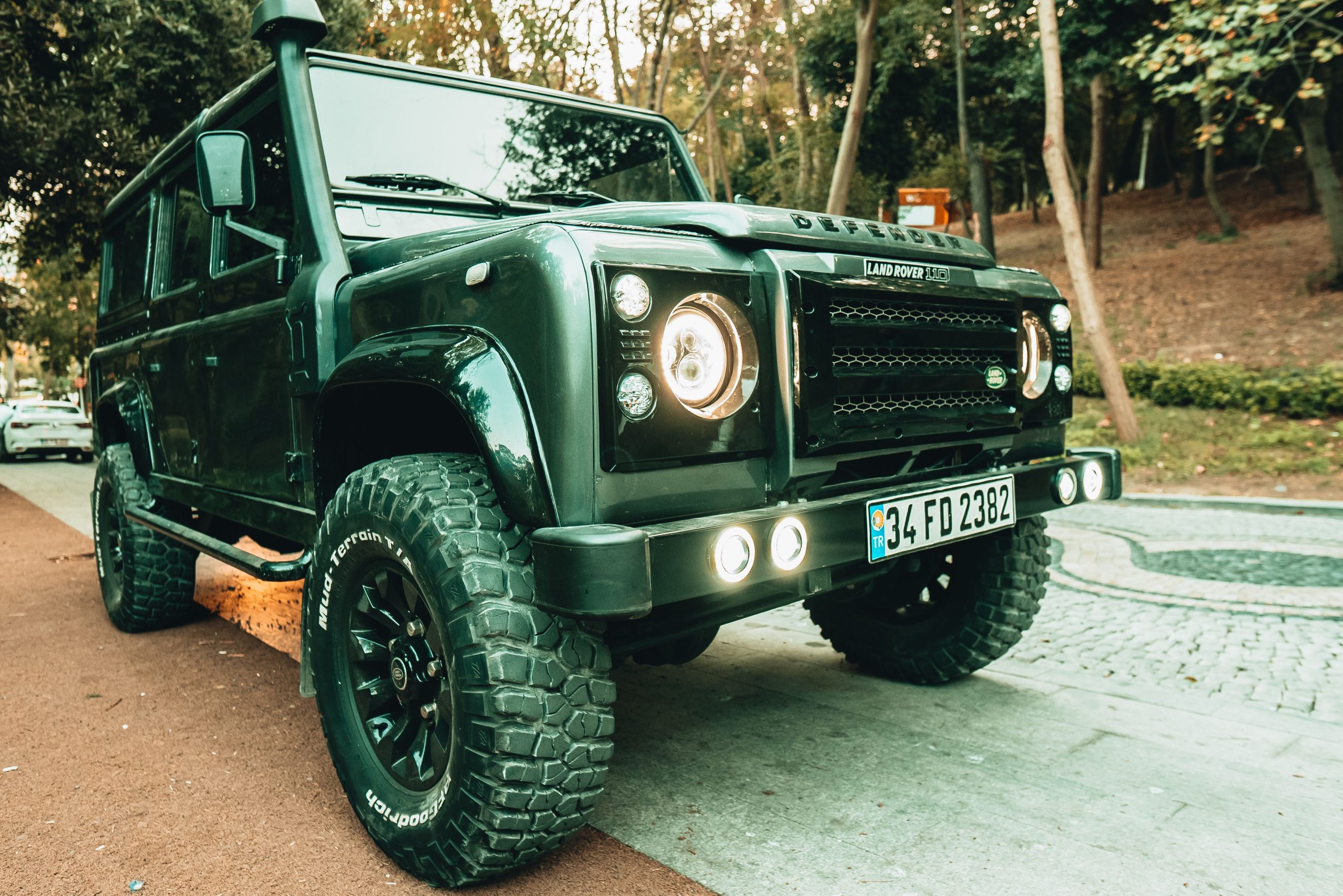 Land Rover Defender parked on a cobblestone street, illustrating the vehicle to import.