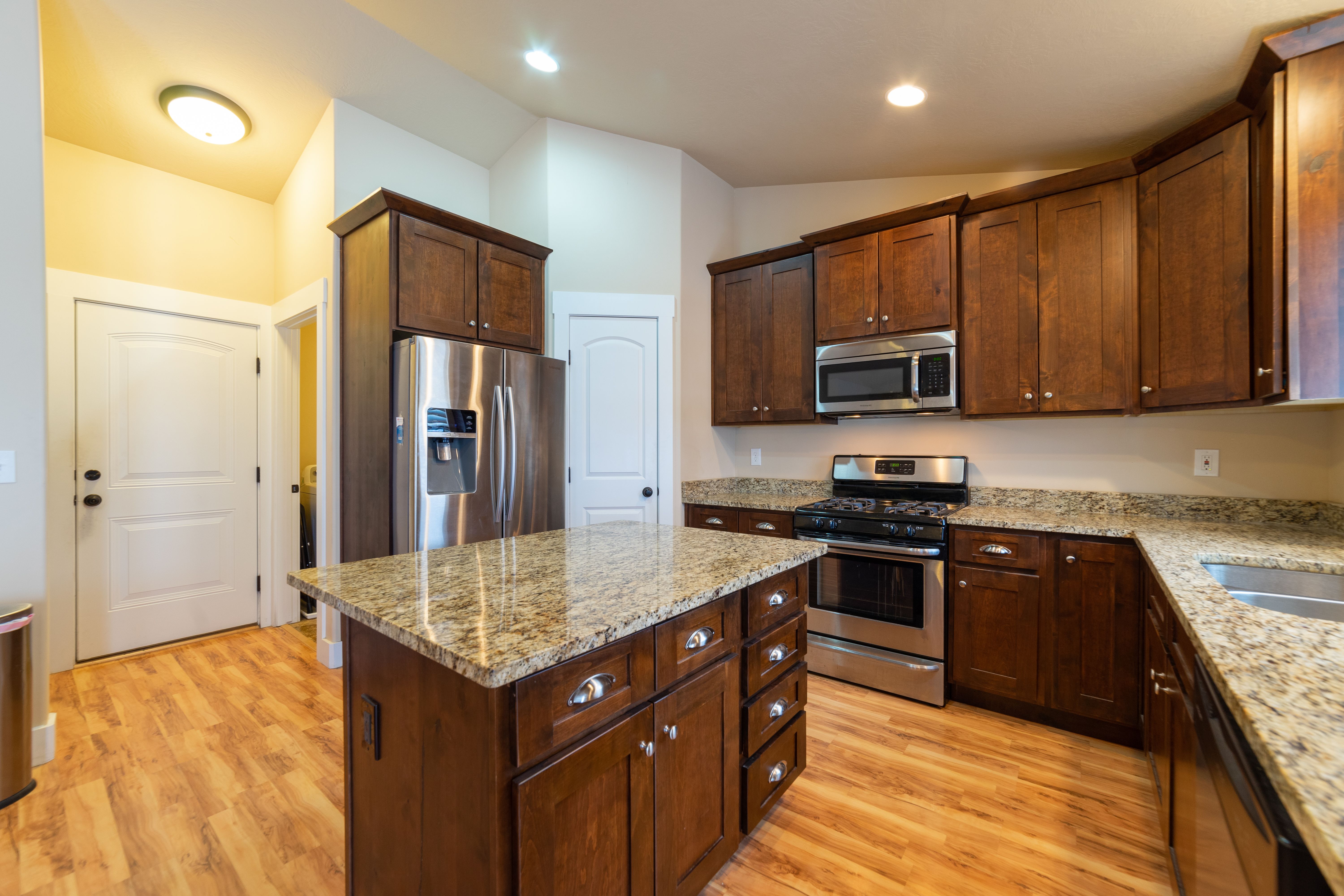 Spacious kitchen with wooden cabinets, granite countertops, and stainless steel appliances
