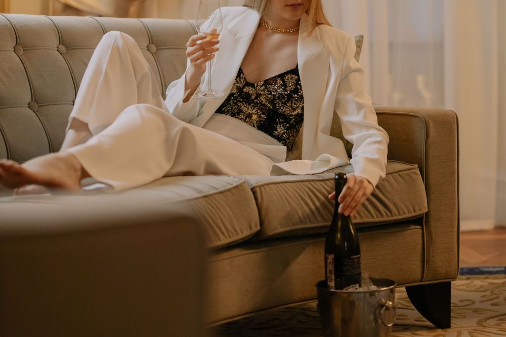Woman relaxing with wine in a luxurious hotel room, suggesting the travel and lifestyle experiences associated with dating.