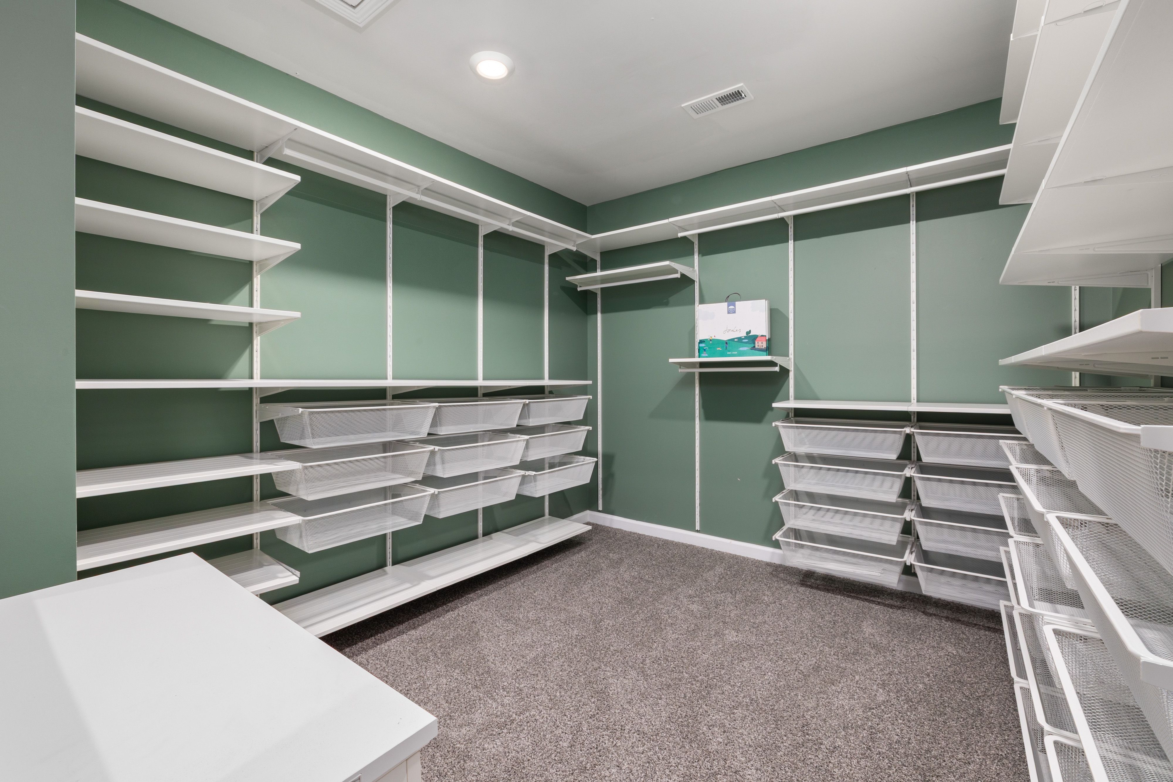 Spacious walk-in closet with modern white shelving and ample storage