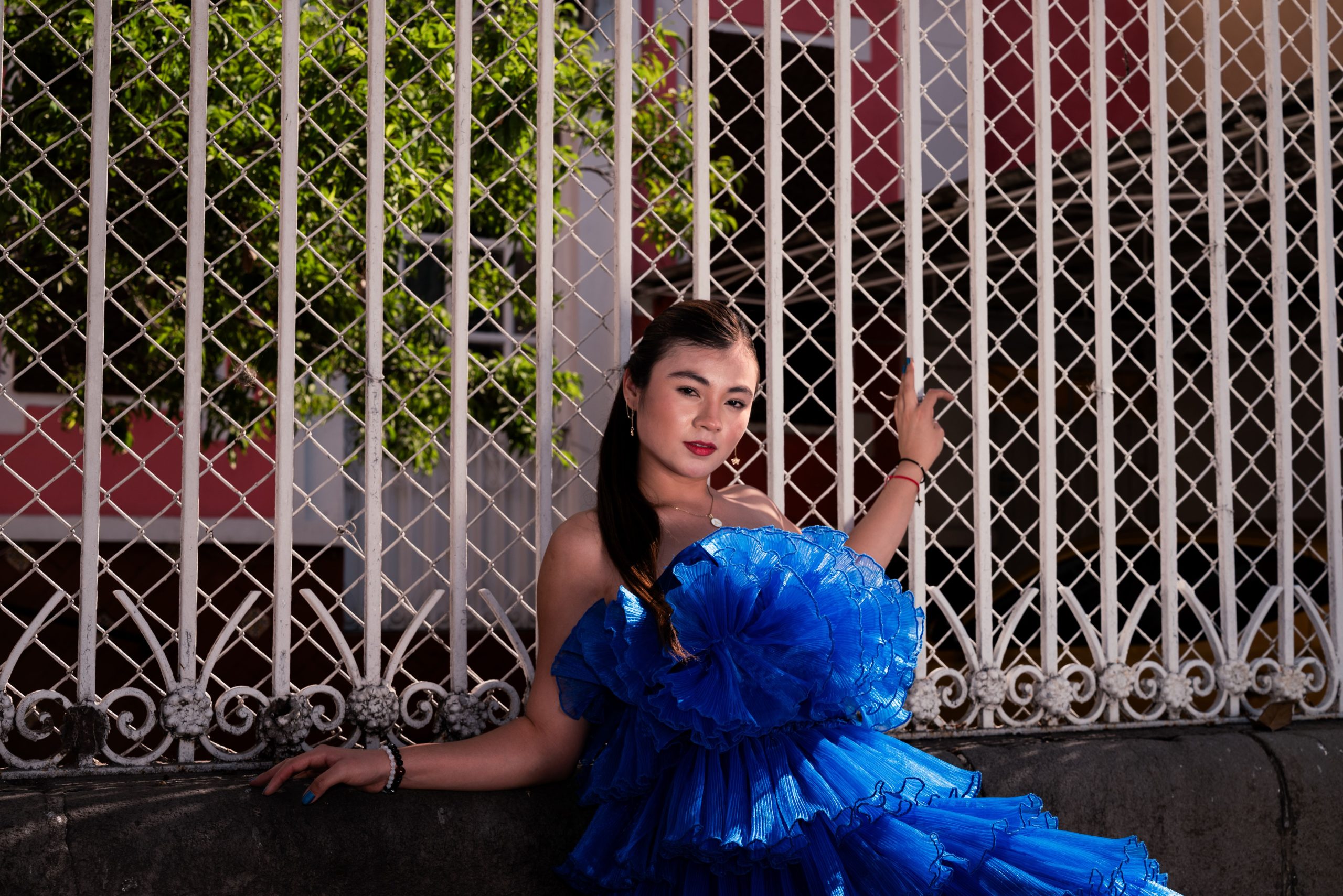 Elegant woman in a blue dress posing confidently outdoors